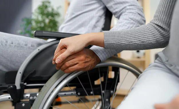 close-up-female-touching-hand-disabled-man-wheelchair-support_93675-126013.avif