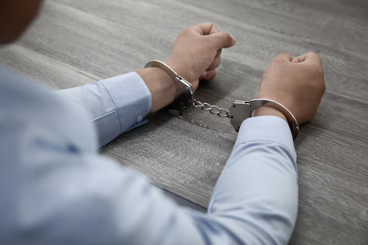 selective-focus-shot-male-hands-handcuffs-wood.width-800.png